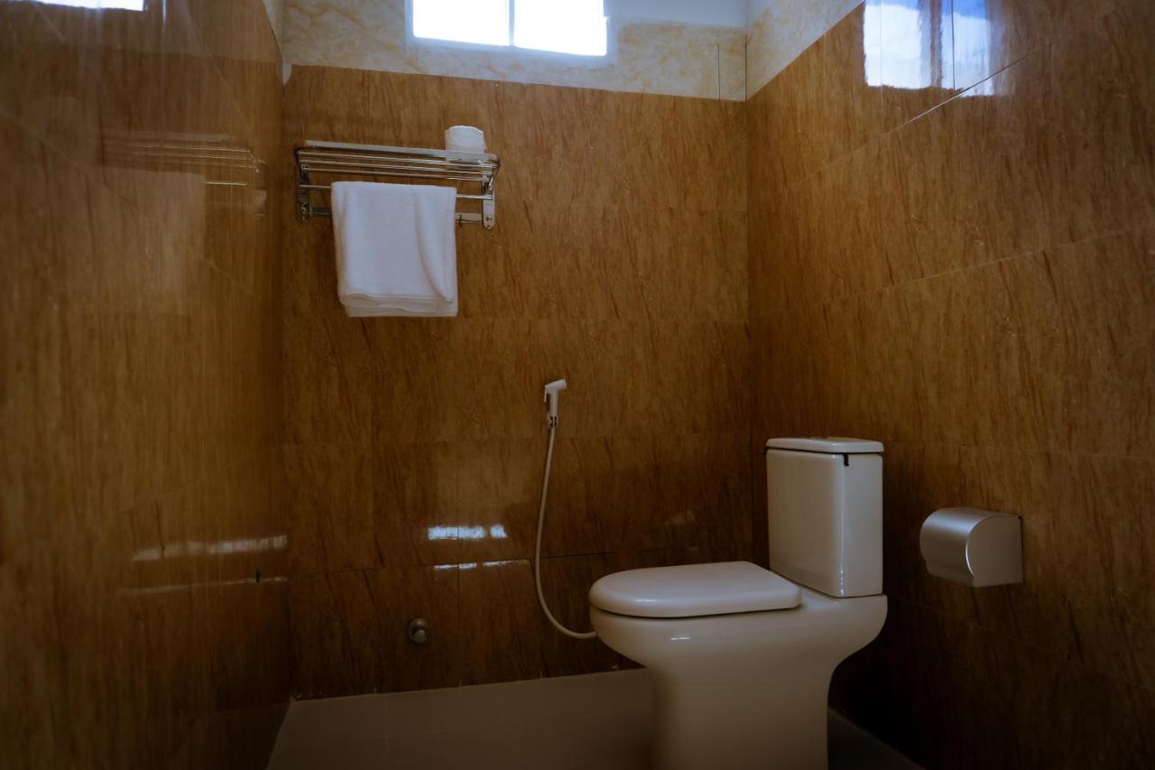 A bathroom with a basin, toilet and hanging towel