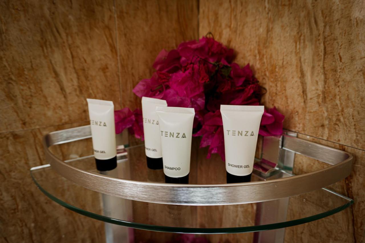 A bathroom vanity with towels, candles and fresh flowers