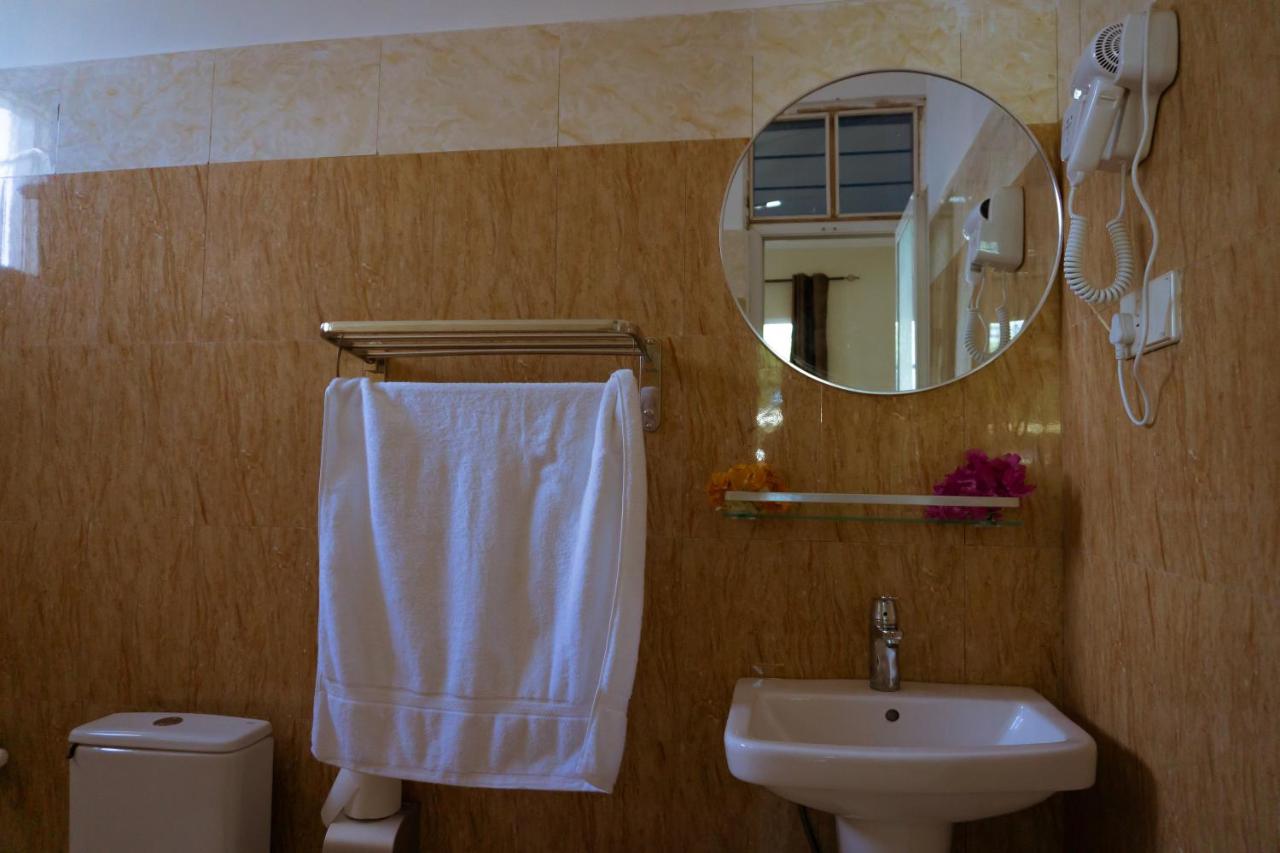 A bathroom basin with a towel hanging beside it