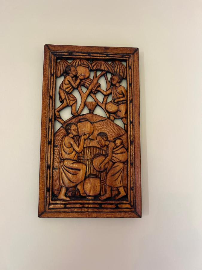A carved Zanzibari wooden panel hanging on a lime-washed wall